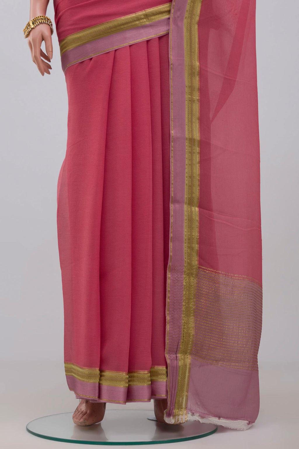Pleats and pallu of Peach Chiffon Saree with Plain Body and Zari Border. 