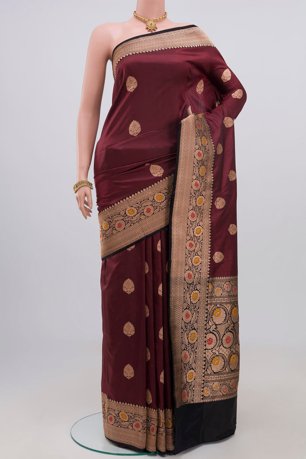 Maroon Banarasi Katan Silk Saree with Zari Butta on the body and Zari Border.  displayed on a mannequin