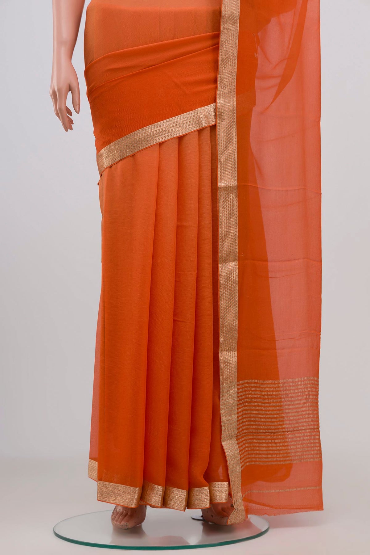 Pleats and pallu of Orange Chiffon Saree with Plain Body and Zari Border. 
