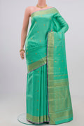 Green Kanjivaram Saree with Zari Butta on the body and Zari Border.  displayed on a mannequin