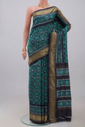 Green Pochampally Silk Saree with Ikat design on the body and Zari Border.  displayed on a mannequin