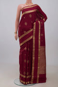Maroon Kanjivaram Silk Saree with Zari Butta on the body and Zari Border.  displayed on a mannequin