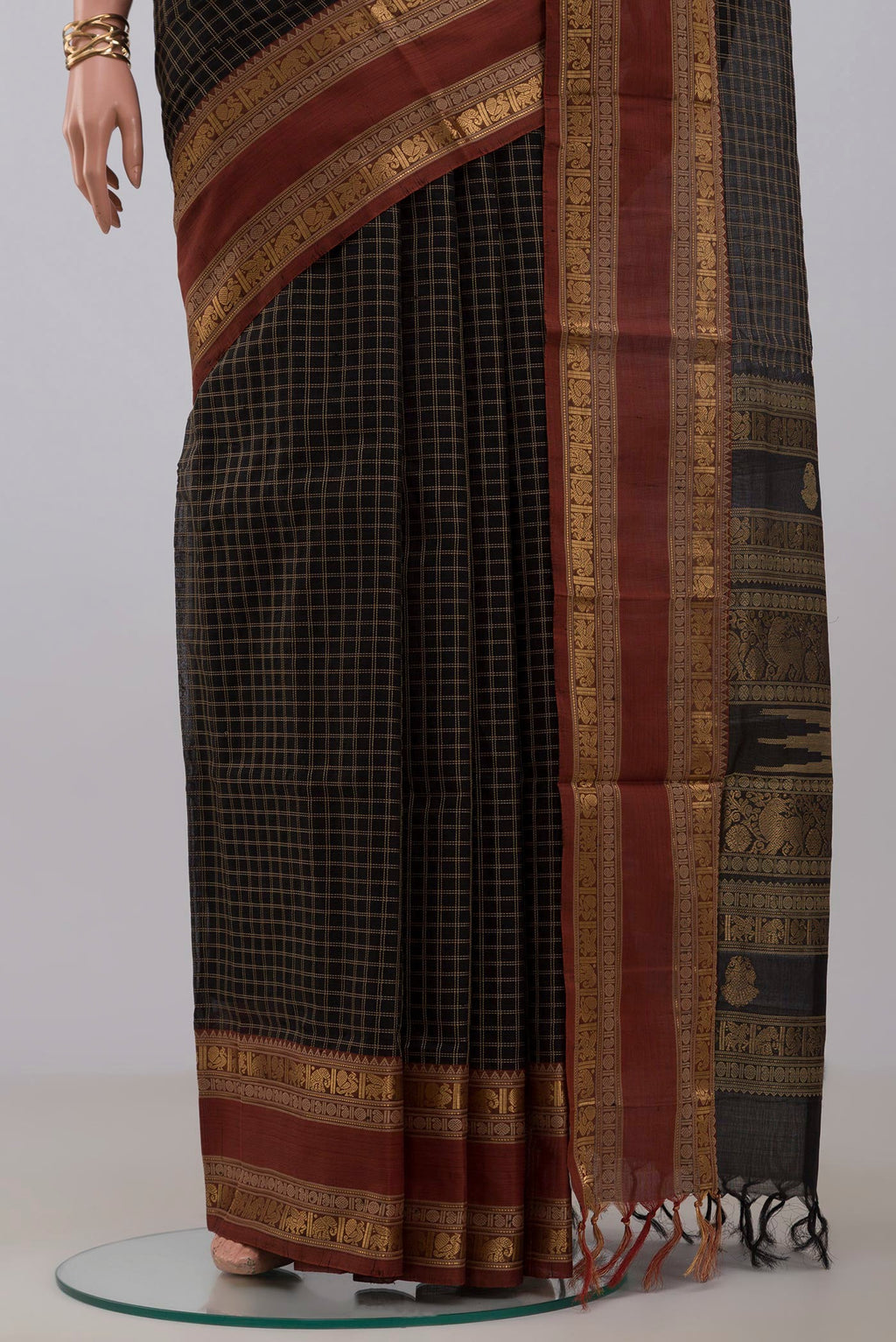 Pleats and pallu of Black Silk Cotton Saree with Checked design on the body and Zari Border. 