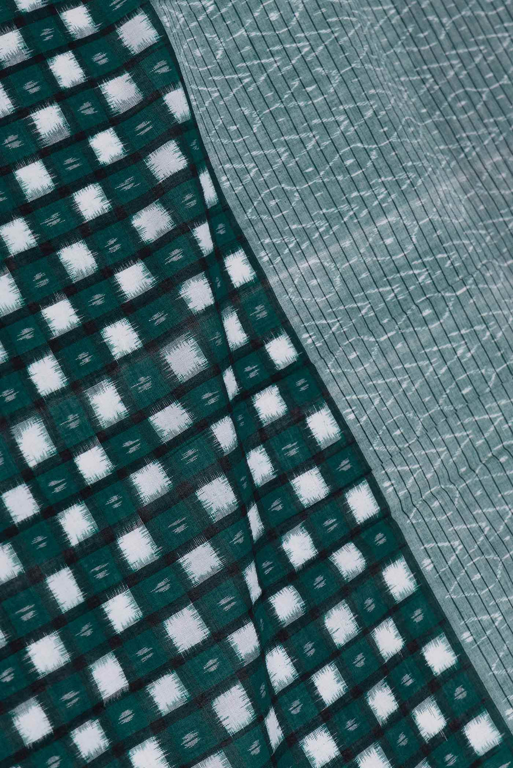 Close up of Green Dual Tone Double Ikat Saree with Ikat Print on the body and Ikat Border displaying folds