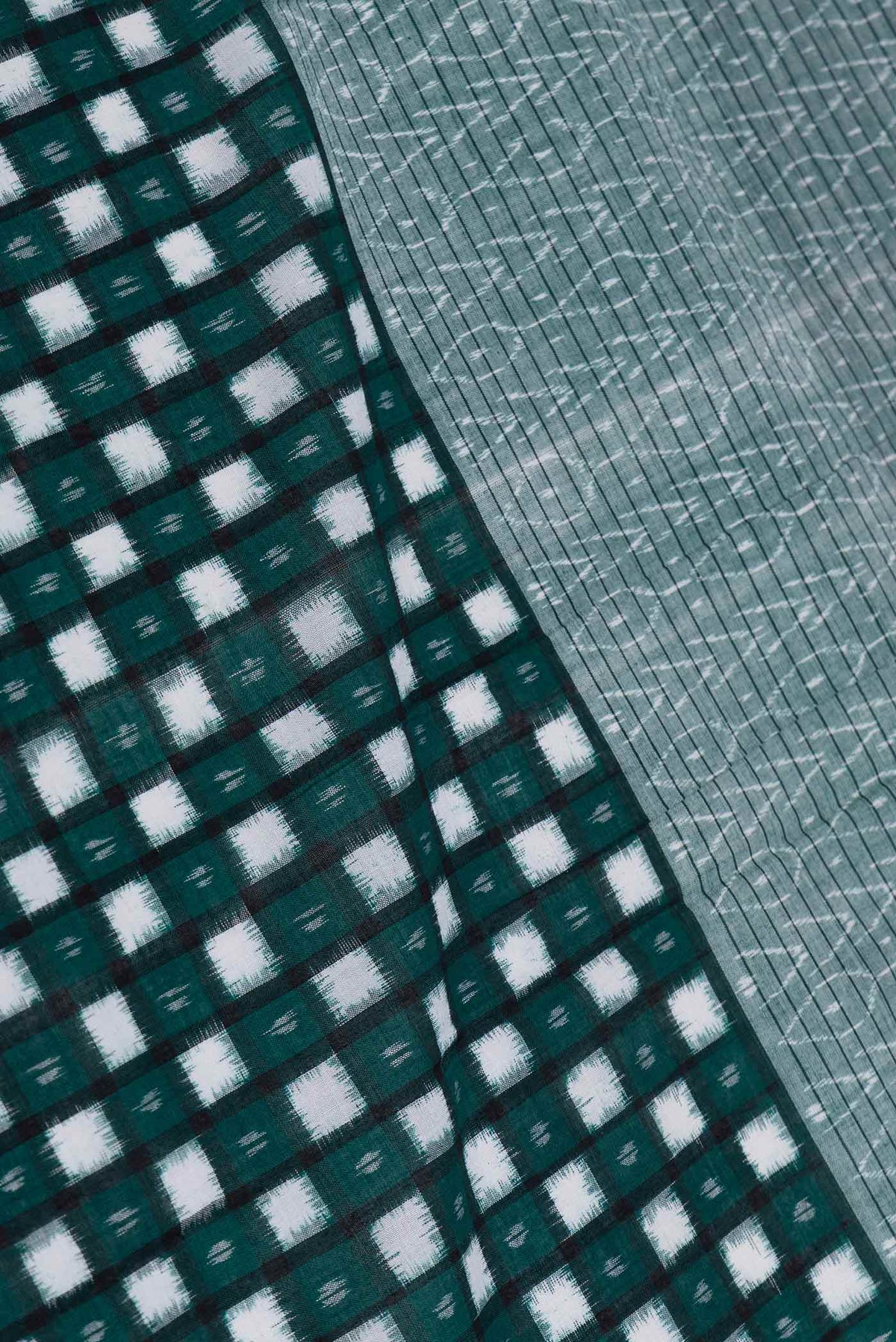 Close up of Green Dual Tone Double Ikat Saree with Ikat Print on the body and Ikat Border displaying folds