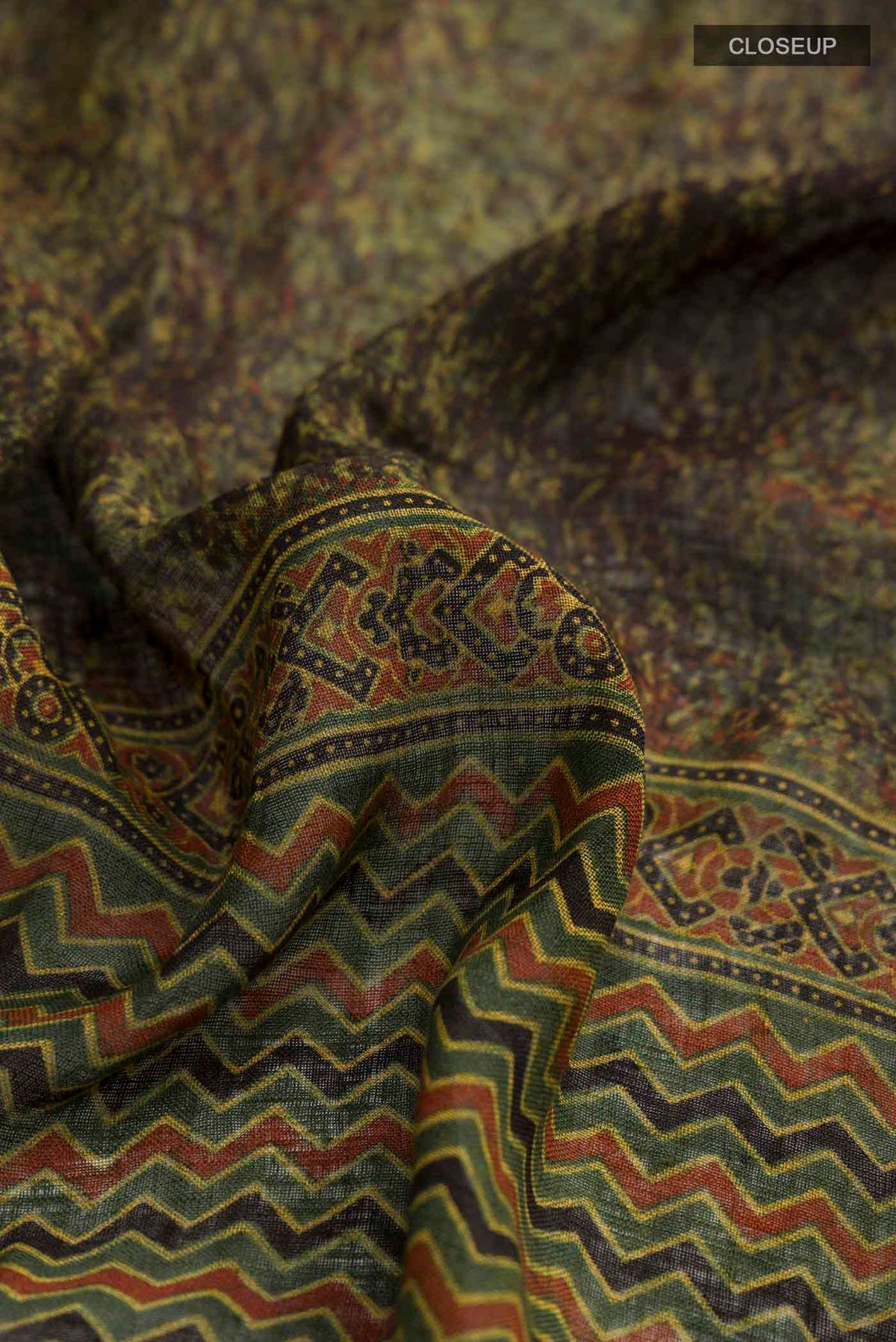 Close up of Green Linen Saree with Printed design on the body and Zari Border displaying folds