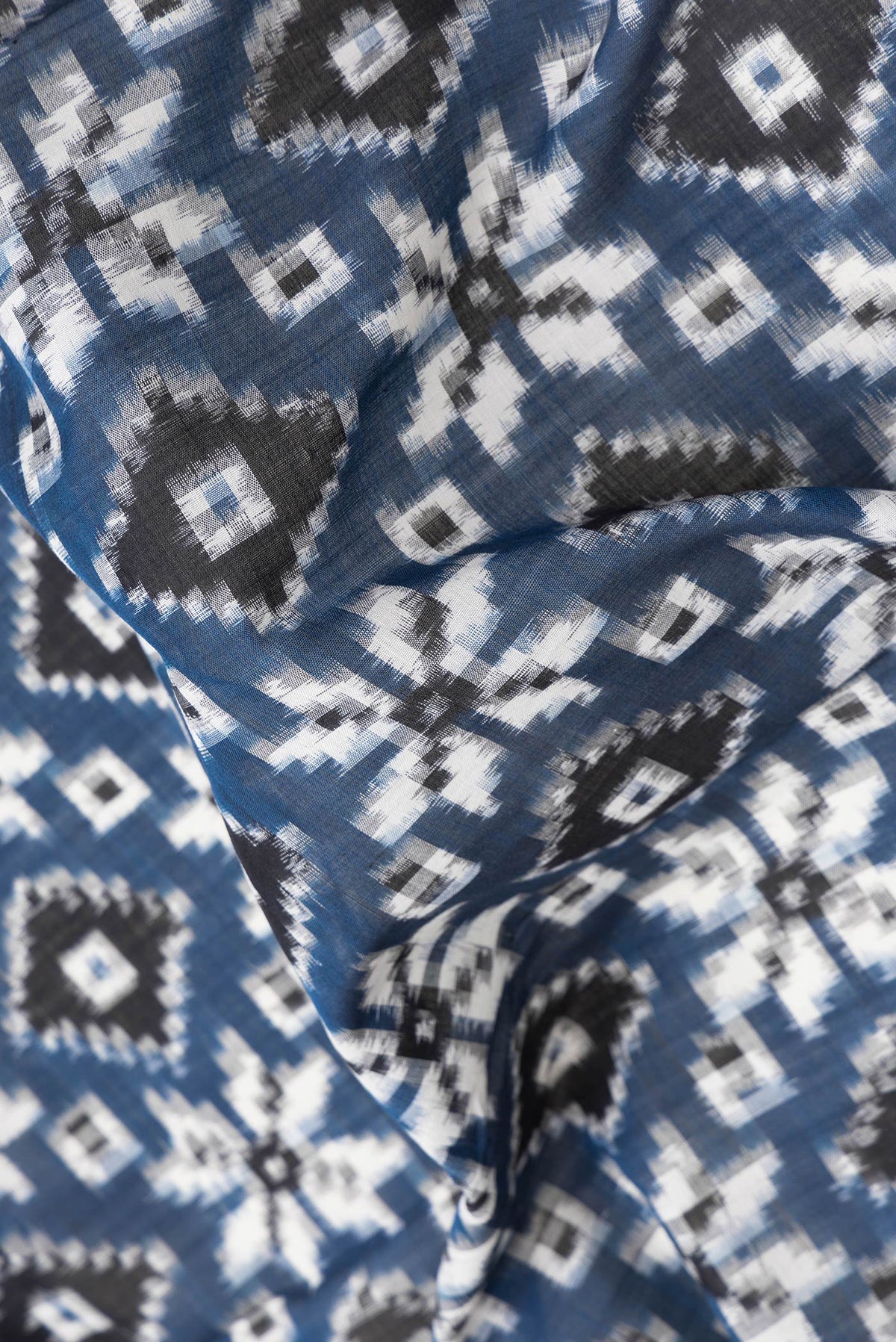 Close up of Blue Dual Tone Double Ikat Saree with Ikat Print on the body and Thread Border.  displaying folds