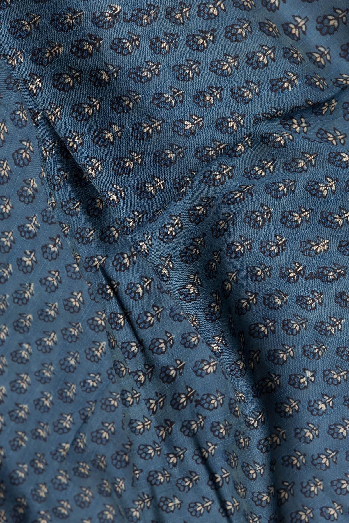 Close up of Blue Grey Dual Tone Tussar Silk Saree with Printed design on the body and Zari Border.  displaying folds