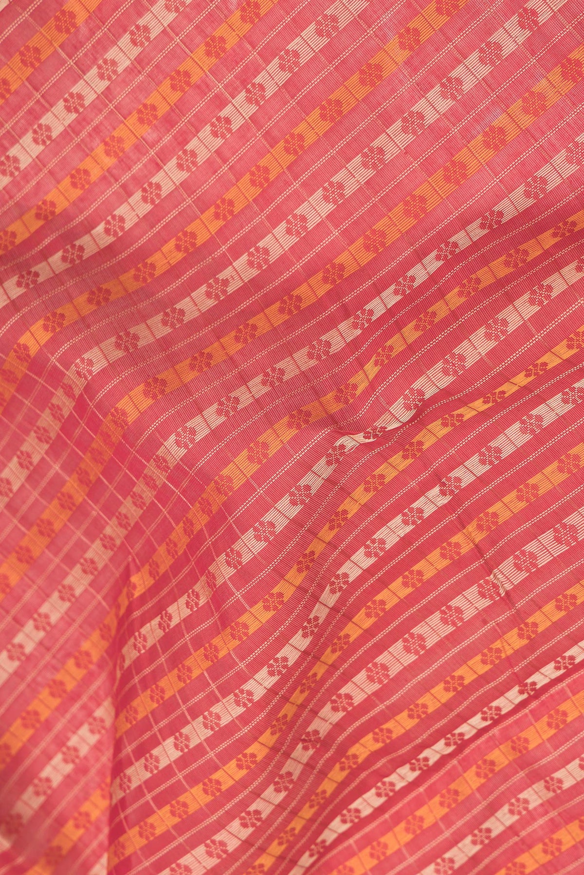 Close up of Red Dual Tone Silk Cotton Saree with Thread Butta on the body and Zari Border.  displaying folds