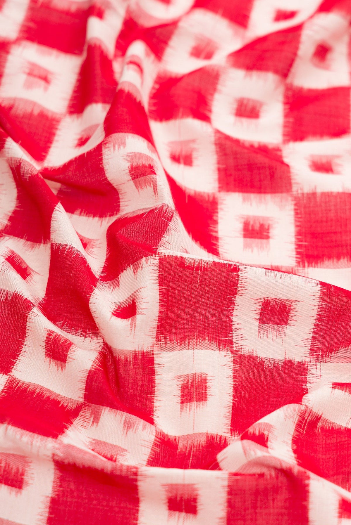 Close up of Red Dual Tone Double Ikat Saree with Ikat Print on the body and Plain Border.  displaying folds