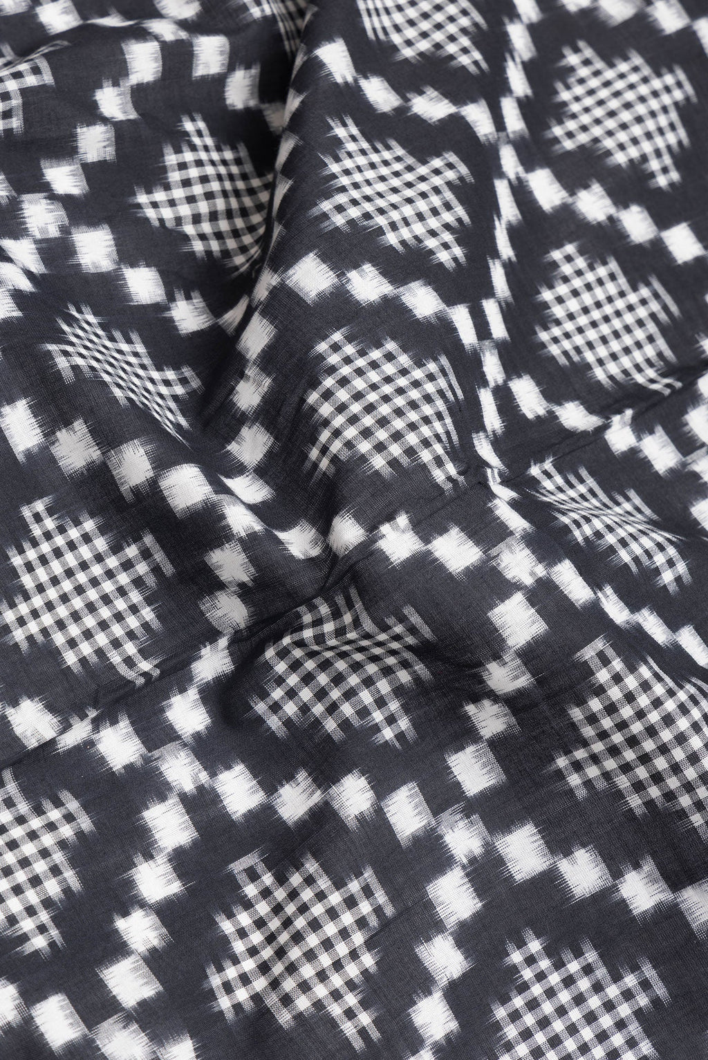 Close up of Black Dual Tone Double Ikat Saree with Ikat Print on the body and Plain Border.  displaying folds