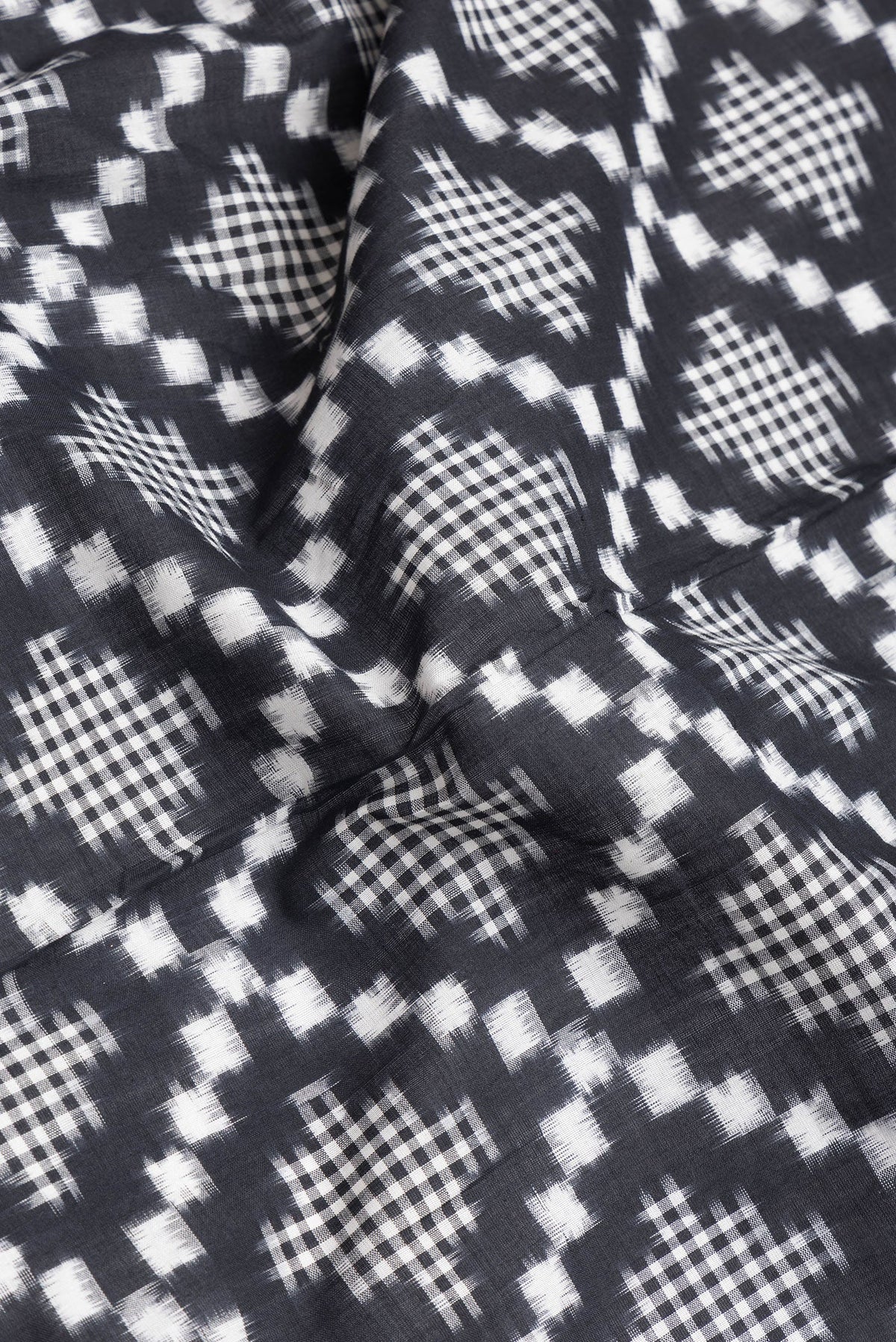 Close up of Black Dual Tone Double Ikat Saree with Ikat Print on the body and Plain Border.  displaying folds