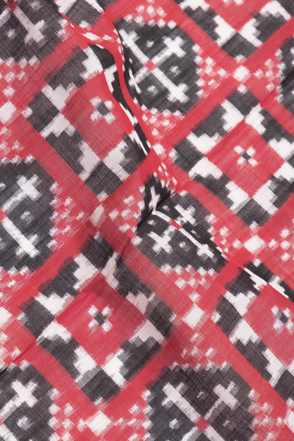 Close up of Black and Red Color Double Ikat Saree with Ikat Print on the body and Plain Border.  displaying folds