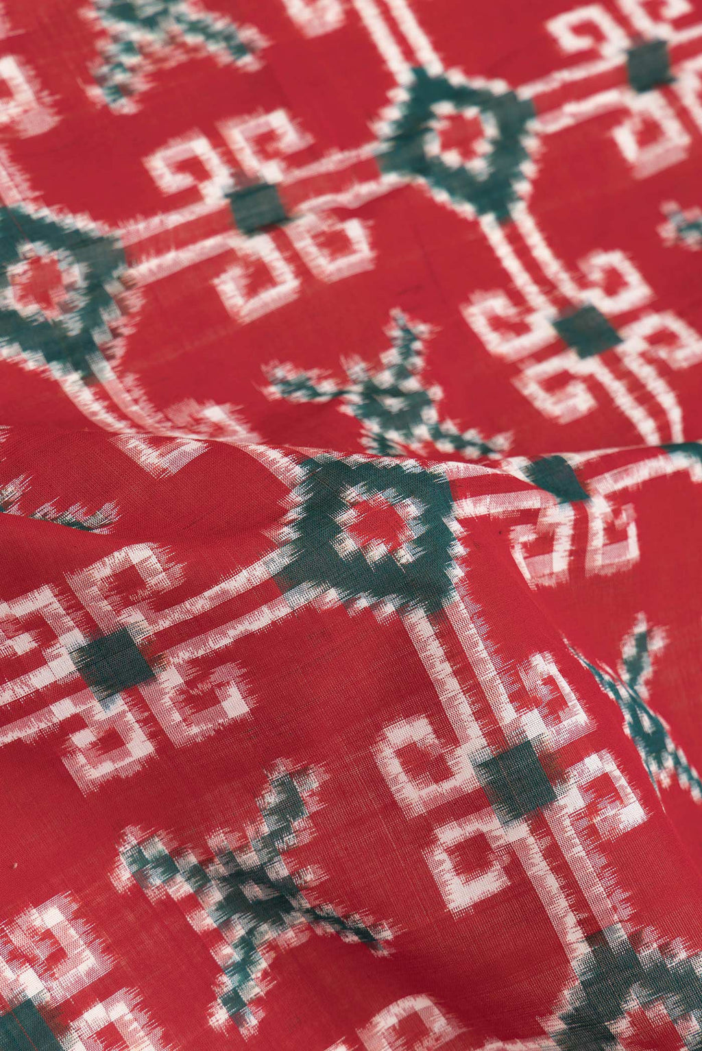 Close up of Red Dual Tone Double Ikat Saree with Ikat Print on the body and Thread Border.  displaying folds