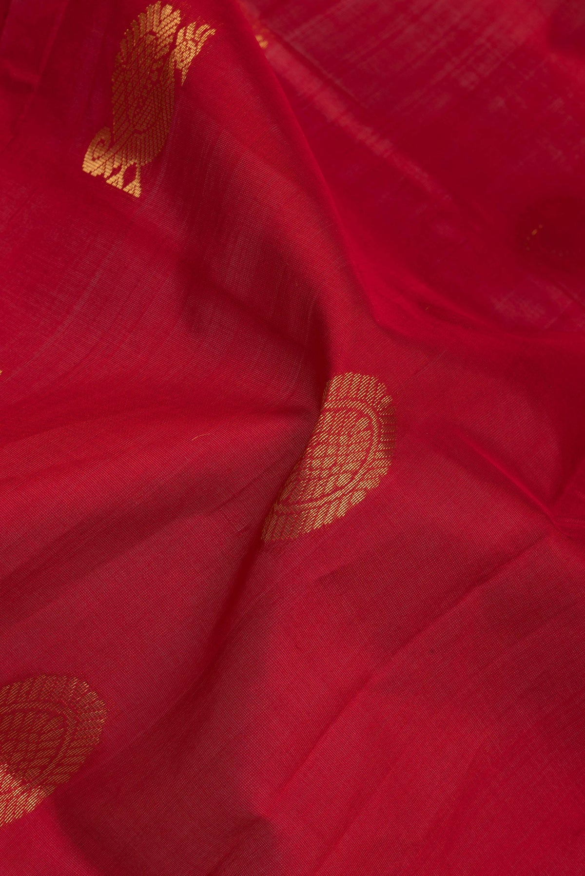 Close up of Red Silk Cotton Saree with Zari Butta on the body and Zari Border.  displaying folds