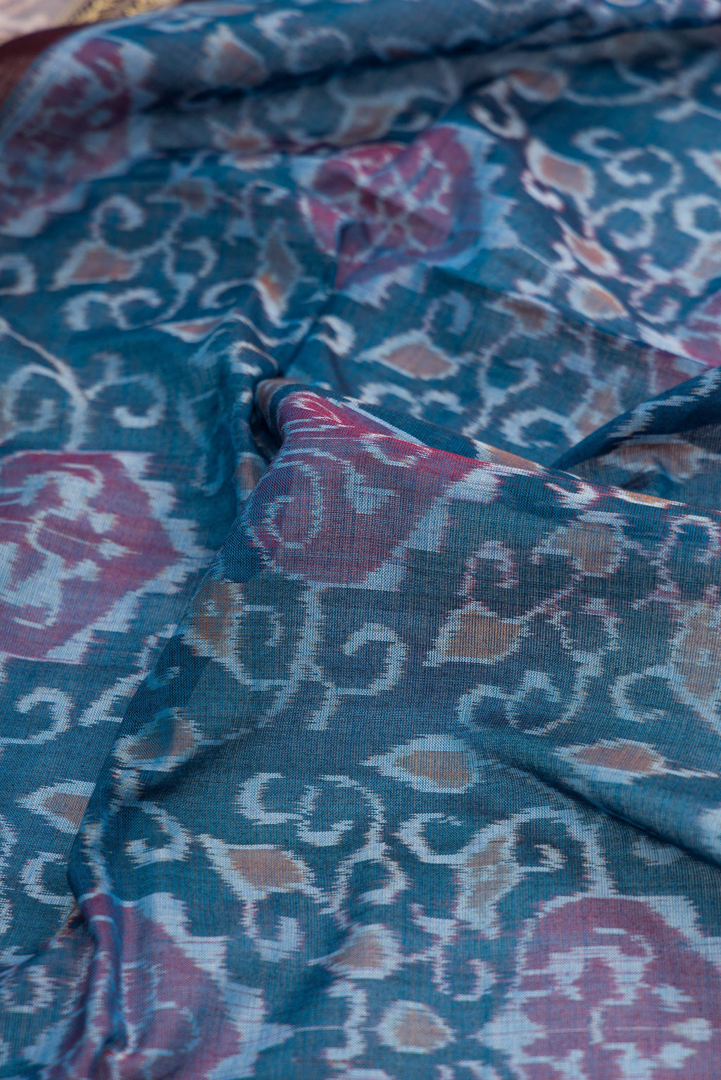 Close up of Blue Dual Tone Double Ikat Saree with Ikat Print on the body and Thread Border.  displaying folds