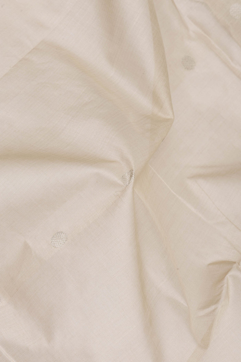 Close up of Beige Uppada Cotton Saree with Zari Butta on the body and Zari Border.  displaying folds