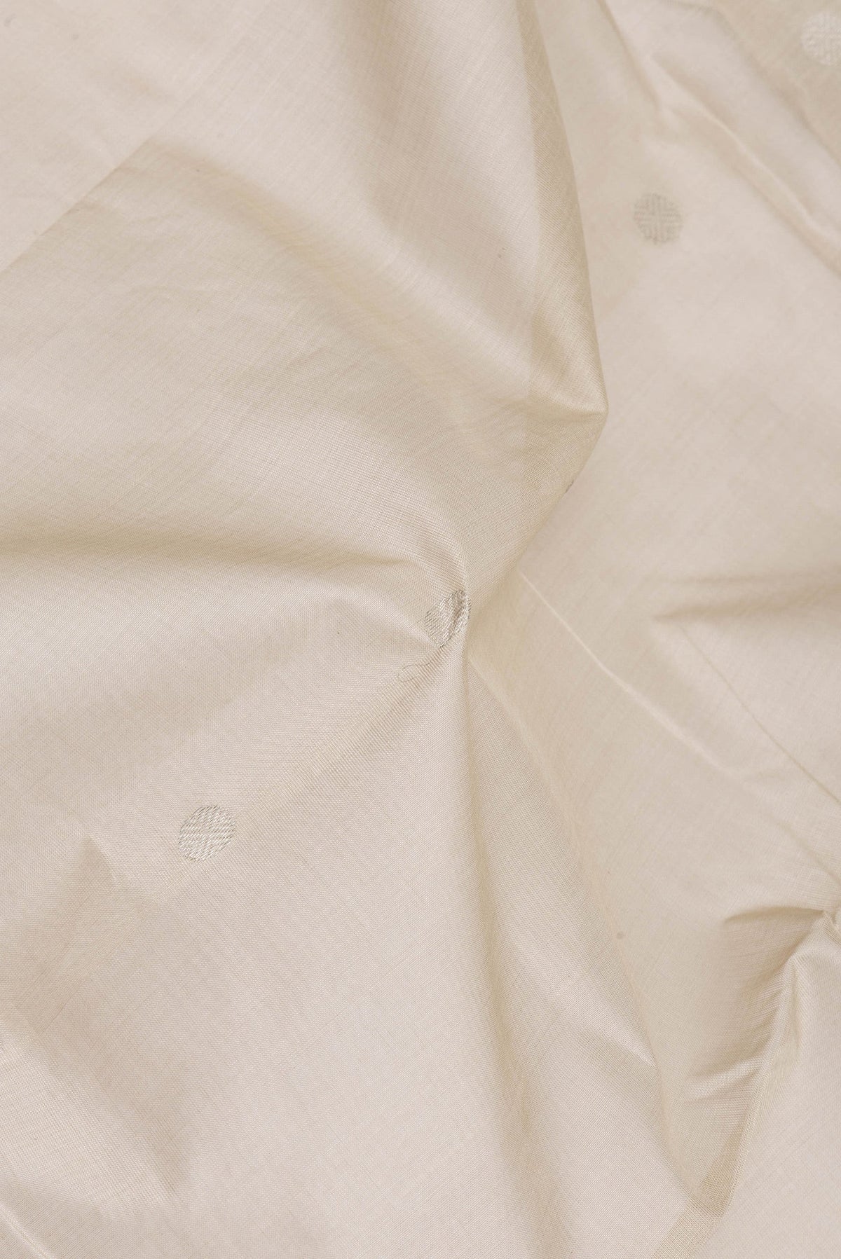 Close up of Beige Uppada Cotton Saree with Zari Butta on the body and Zari Border.  displaying folds