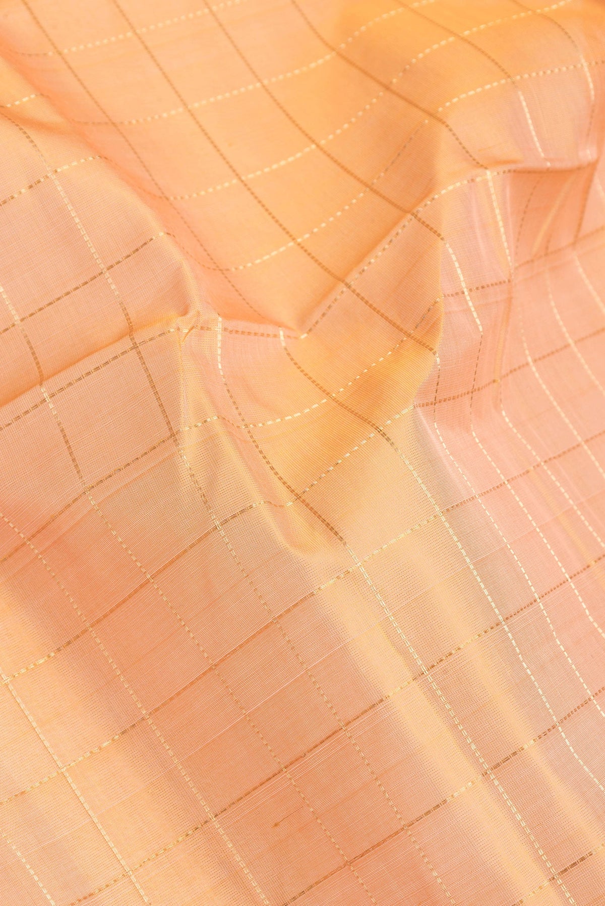 Close up of Golden Peach Dual Tone Silk Cotton Saree with Checked design on the body and Zari Border.  displaying folds