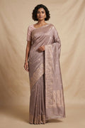 Model wearing a Mandhara, handwoven in Katan silk, brings together kadhua weaving and delicate meenakari detailing. Crafted in gold zari with silver accents, the saree draws from Art Nouveau florals and the concentric forms of Dhokra metal craft. Wavy, concentric borders with floral vines frame the design, while tiny silver-meenakari butis dot the body. The pallu completes the saree with elongated floral panels, lending a balanced, composed finish.