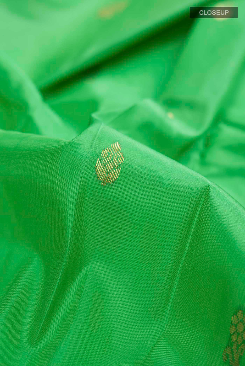 Close up of Green Kanchipuram Silk Saree with Zari Butta on the body and One Side Border displaying folds