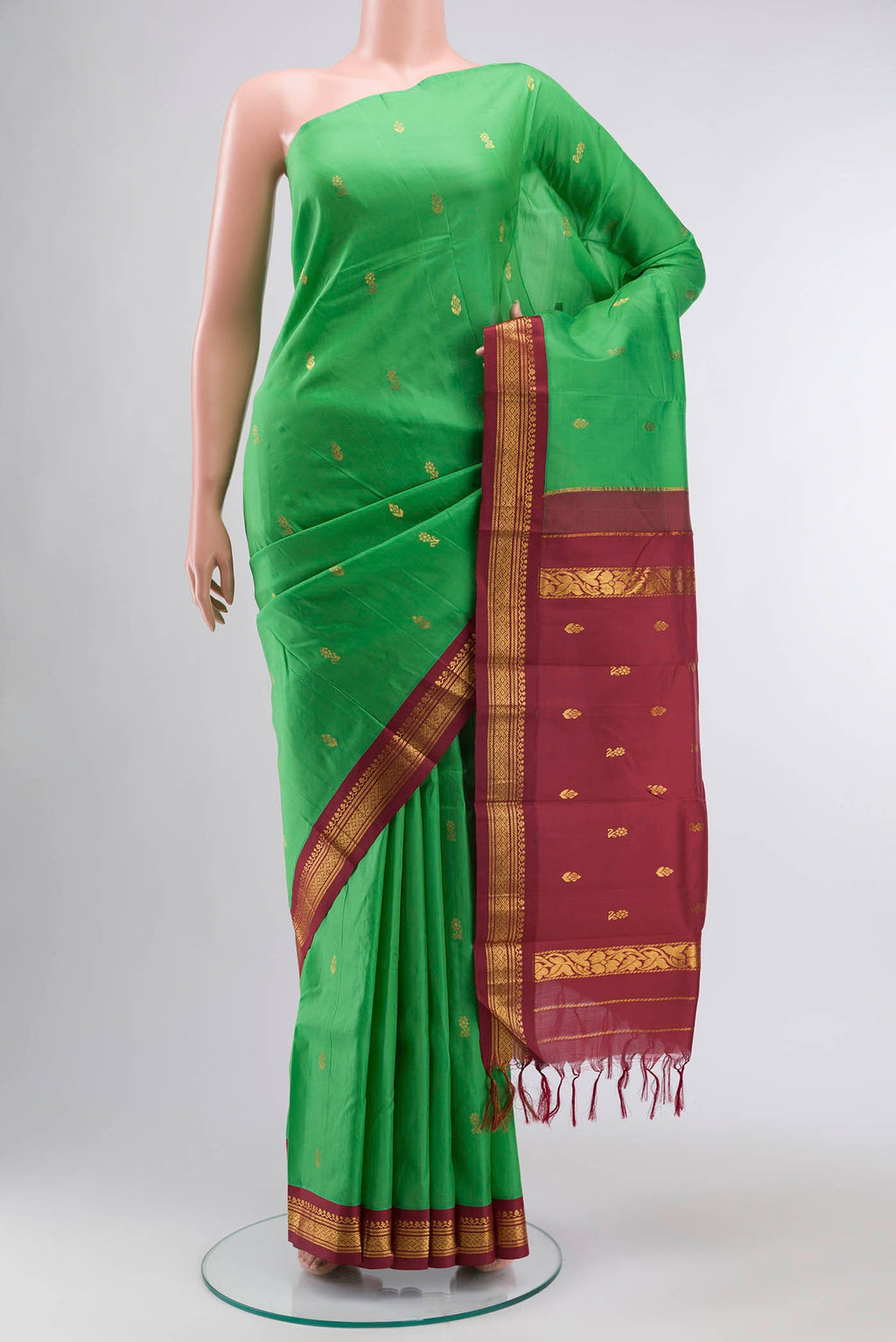 Green Kanchipuram Silk Saree with Zari Butta on the body and One Side Border displayed on a mannequin