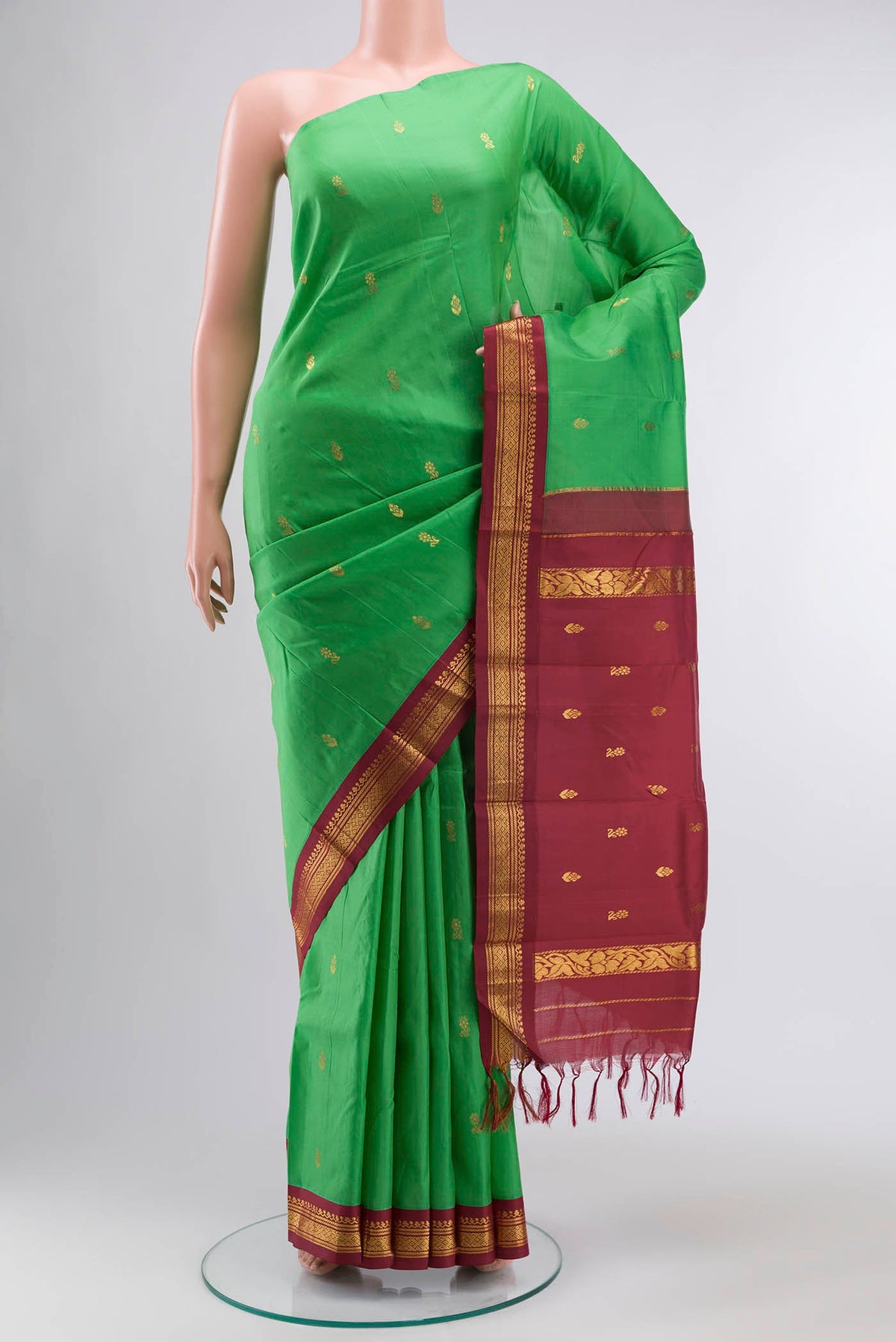 Green Kanchipuram Silk Saree with Zari Butta on the body and One Side Border displayed on a mannequin