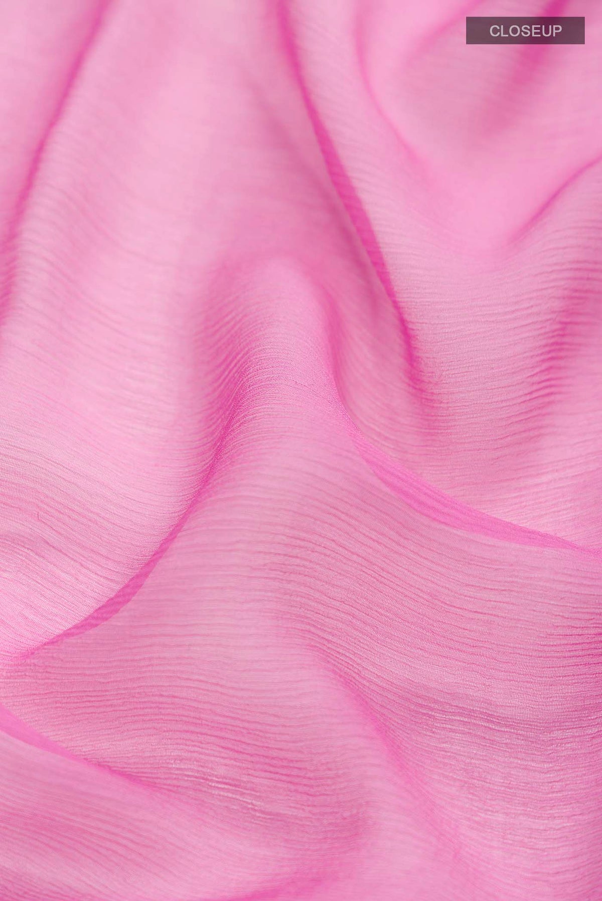 Close up of Pink Chiffon Saree with Plain Body and Zari Border displaying folds