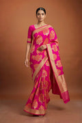 Model wearing a Pure Silk Pure Zari Rani Pink Banarasi Saree with Zari Butta on the body and Attached Border.