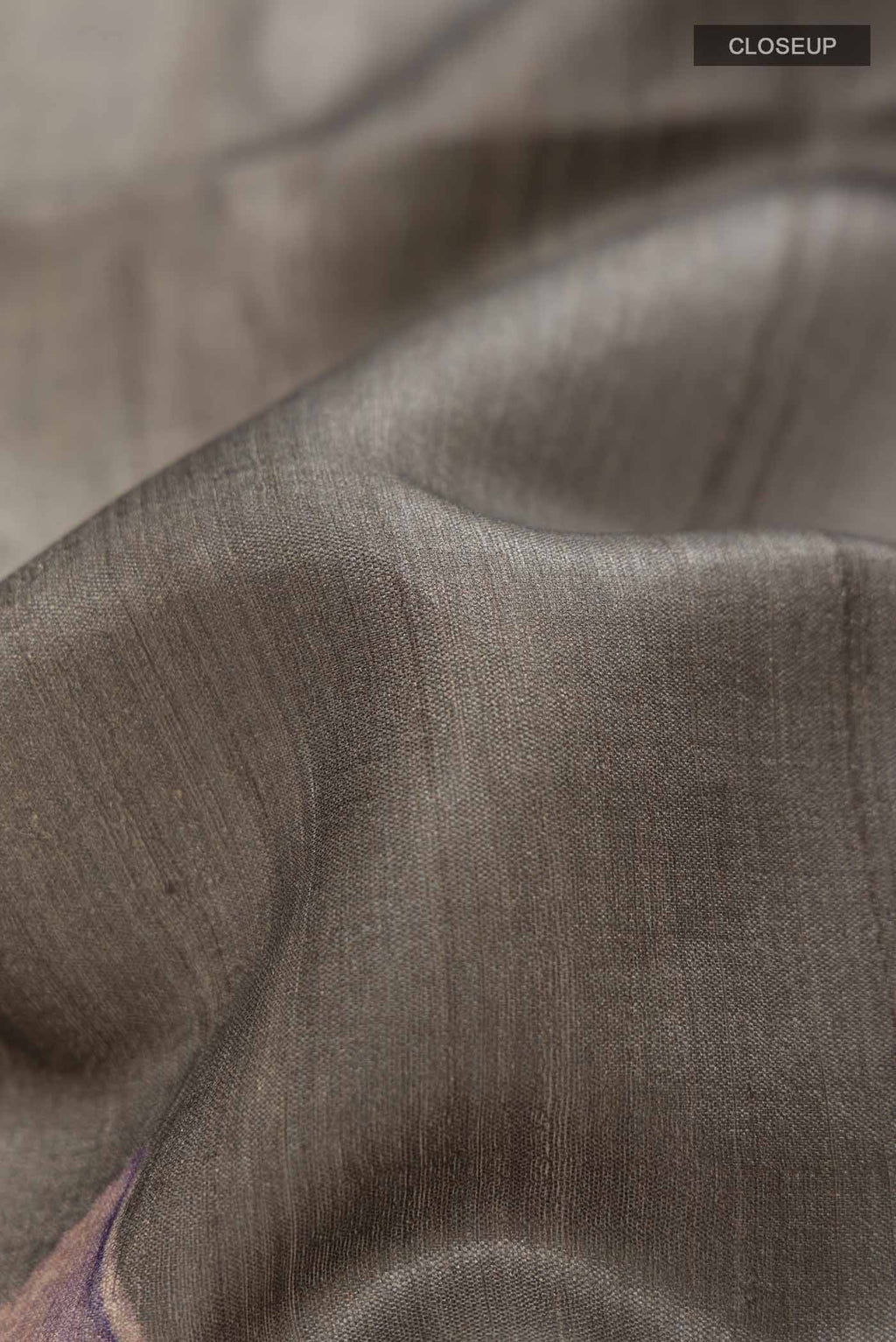 Close up of Grey Tussar Saree with Plain Body and Zari Border displaying folds