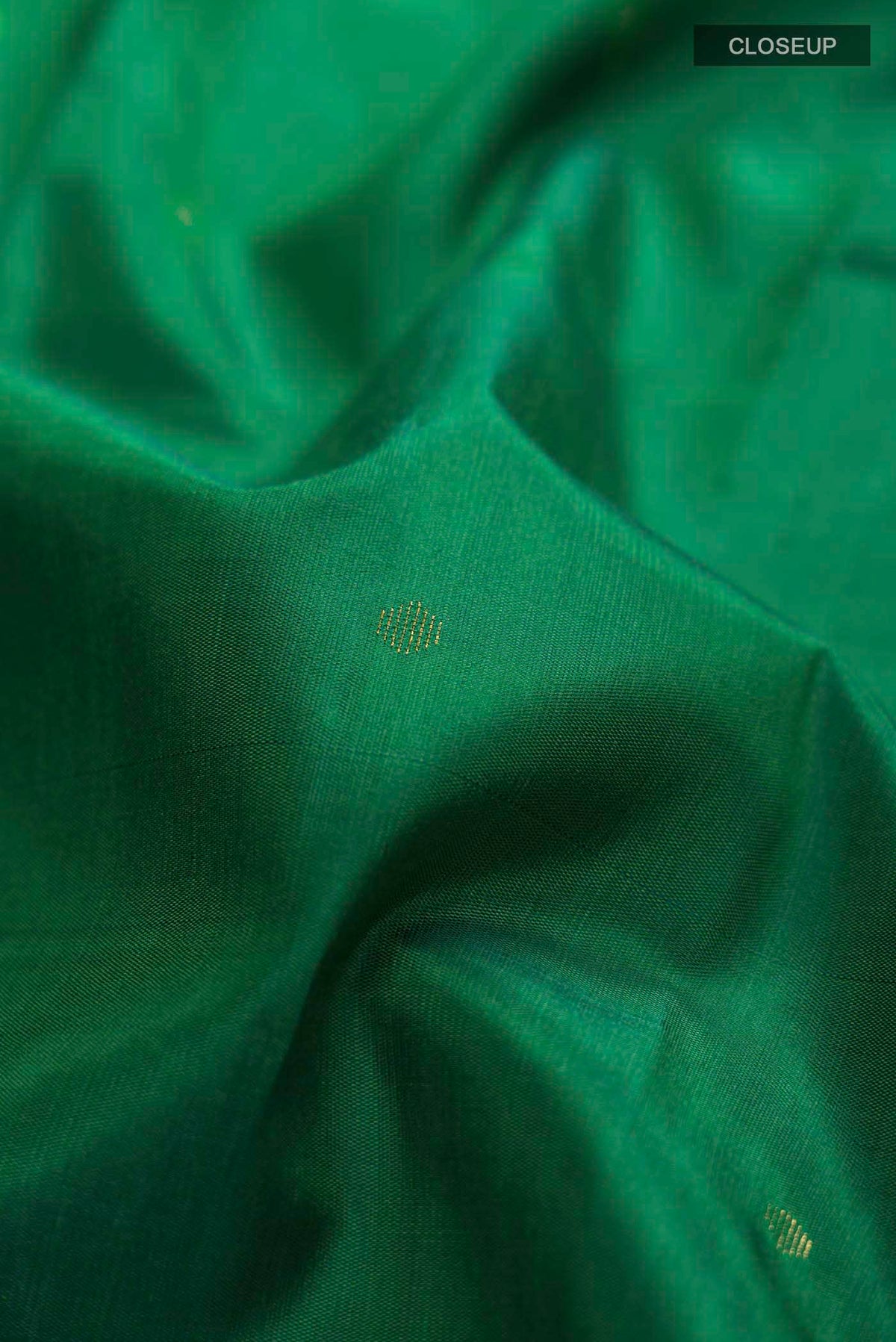 Close up of Green Kanchipuram Silk Saree with Zari Butta on the body and Zari Border displaying folds