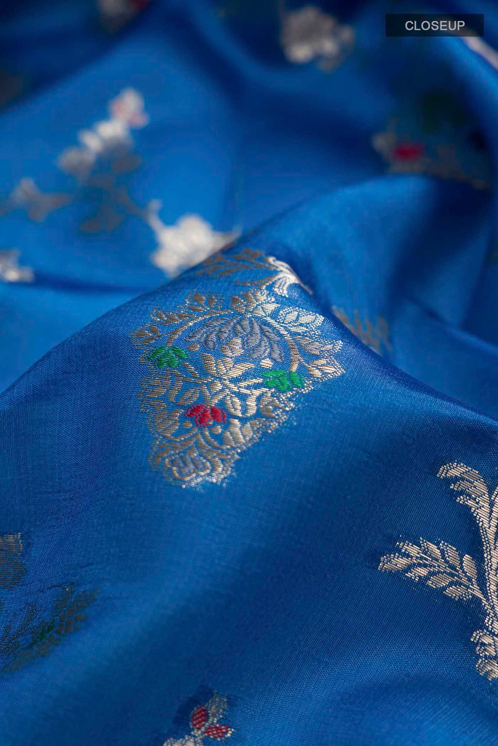 Close up of Blue Banarasi Raw Silk Saree with Zari Butta on the body and Zari Border displaying folds