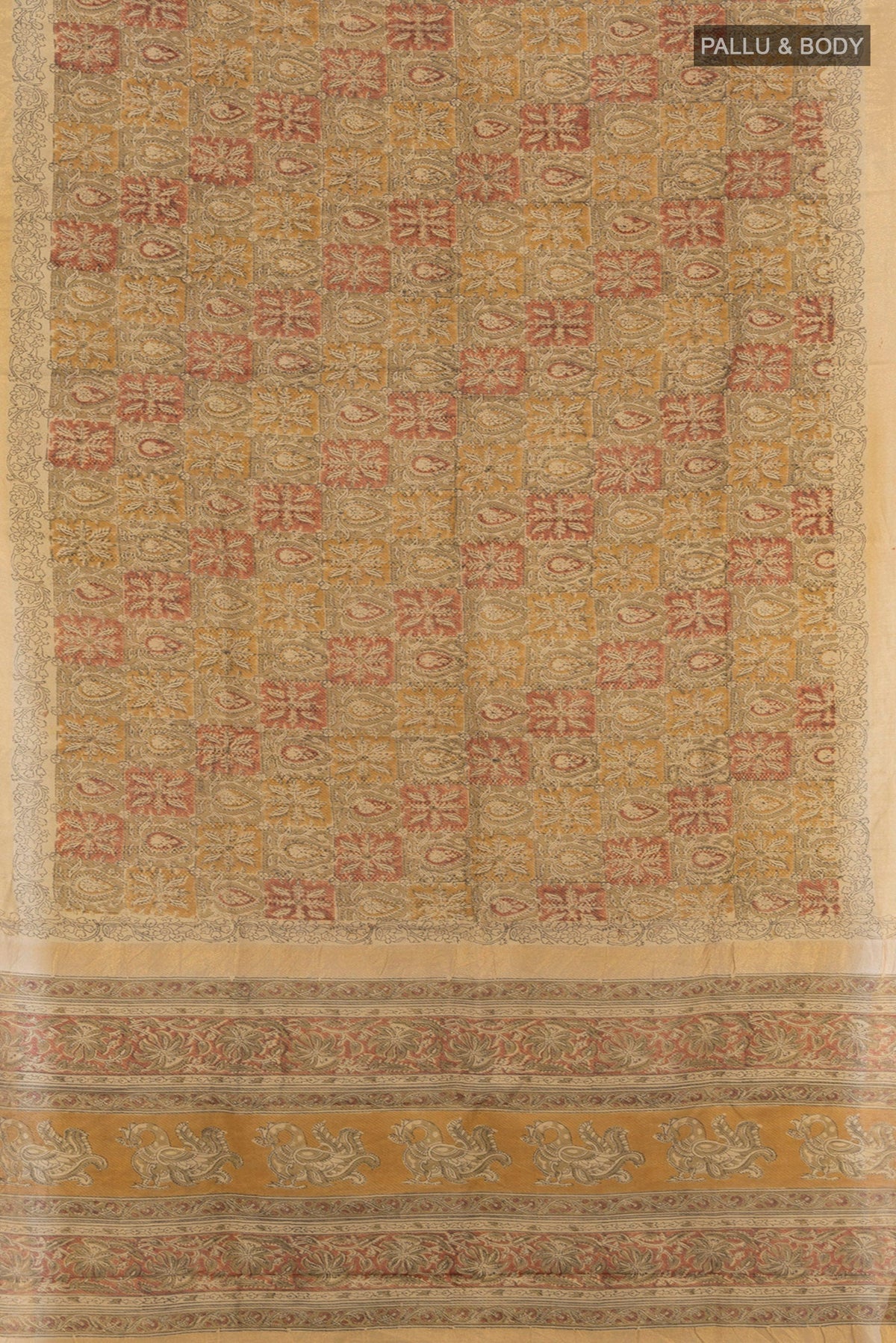 Flat view of Beige Tussar Silk Saree with kalamkari Print on the body and Zari Border. 