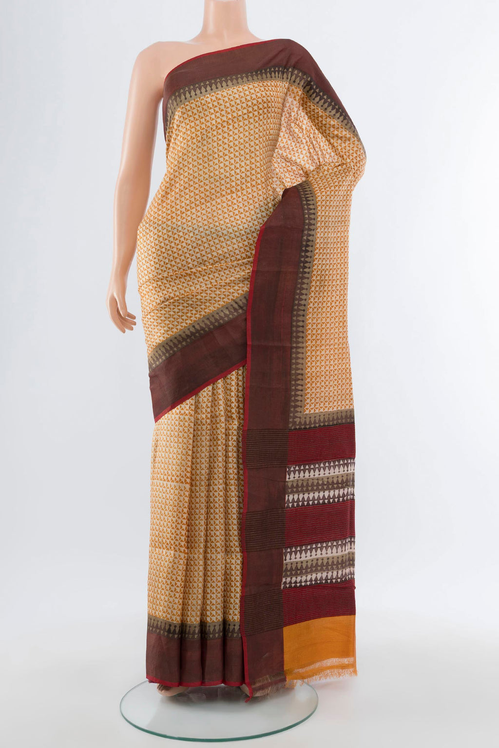 Beige Tussar Silk Saree with Printed design on the body and Zari Border.  displayed on a mannequin