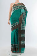 Peacock Blue Tussar Silk Saree with Floral Print on the body and Silk Border.  displayed on a mannequin