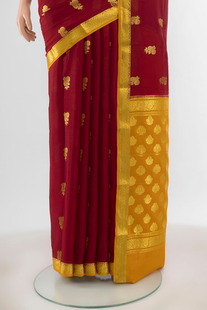 Pleats and pallu of Maroon Mysore Crepe Saree with Zari Butta on the body and Zari Border. 