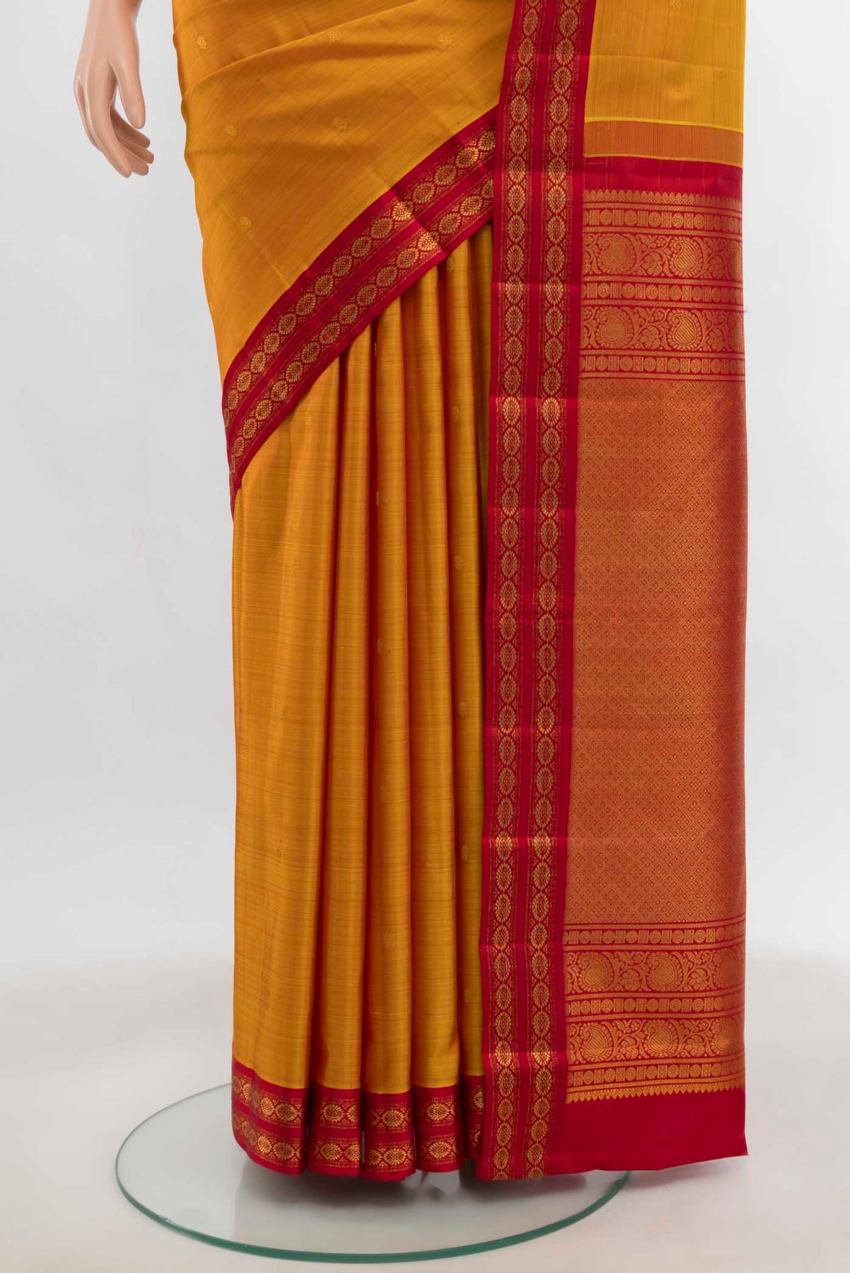 Pleats and pallu of Mustard Kanchipuram Silk Saree with Zari Butta on the body and Zari Border. 