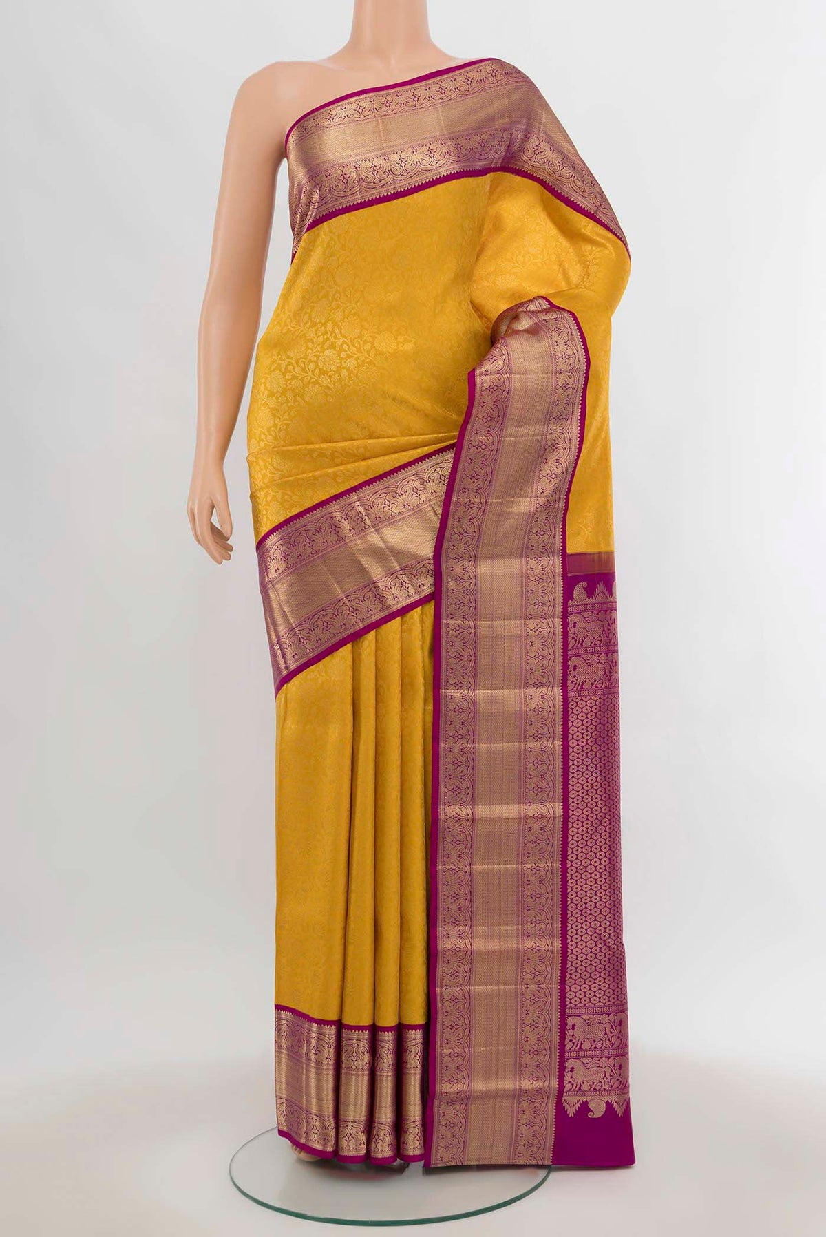 Yellow Kanchipuram Silk Saree with Zari Butta on the body and Silk Border.  displayed on a mannequin