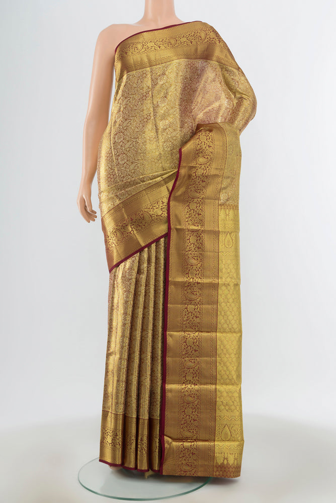 Golden Kanchipuram Silk Saree with Zari Butta on the body and Zari Border.  displayed on a mannequin