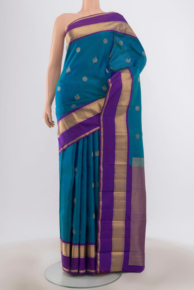 Peacock Blue Kanchipuram Silk Saree with Zari Butta on the body and Zari Border.  displayed on a mannequin