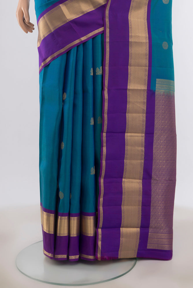 Pleats and pallu of Peacock Blue Kanchipuram Silk Saree with Zari Butta on the body and Zari Border. 