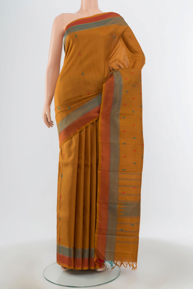Mustard Kanchipuram Silk Saree with Thread Butta on the body and Plain Border.  displayed on a mannequin