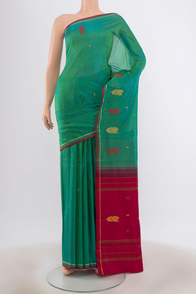 Green with Blue Color Kanchipuram Silk Saree with Zari Butta on the body and Zari And Thread Border.  displayed on a mannequin