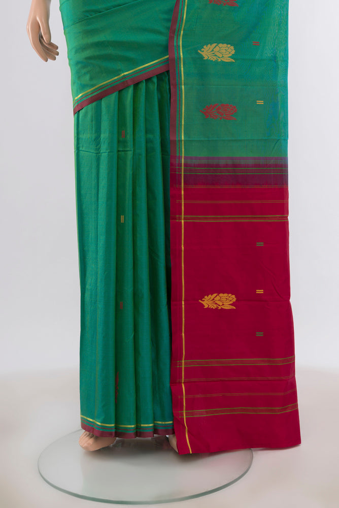 Pleats and pallu of Green with Blue Color Kanchipuram Silk Saree with Zari Butta on the body and Zari And Thread Border. 