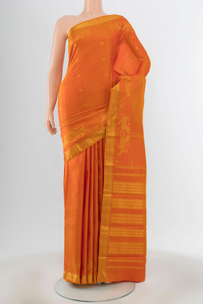 Mustard Kanjivaram Silk Saree with Zari Butta on the body and Zari Border.  displayed on a mannequin