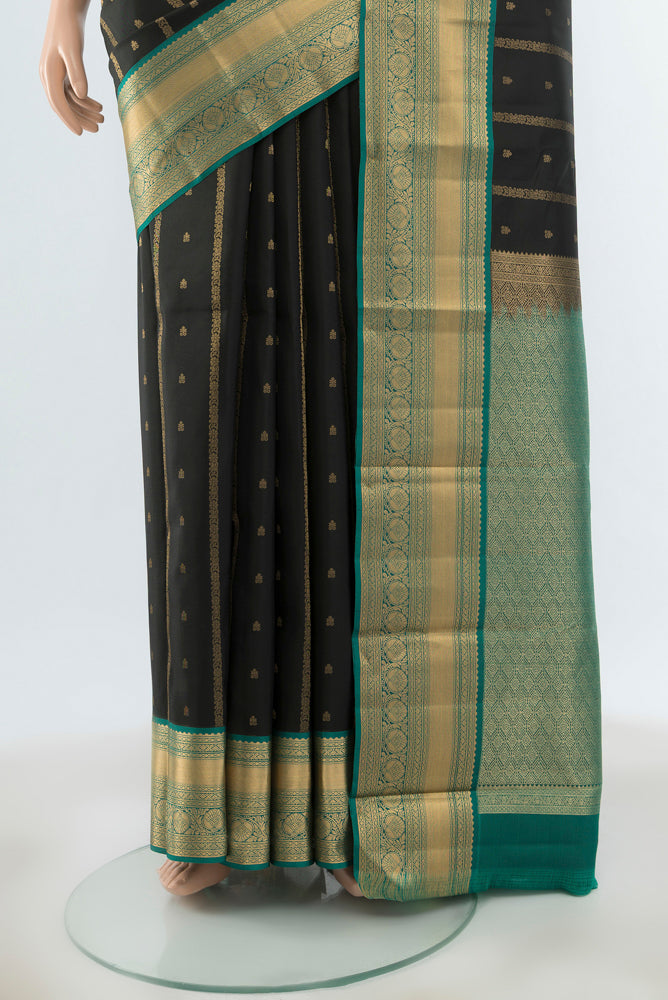 Pleats and pallu of Black Kanchipuram Silk Saree with Zari Butta on the body and Zari Border. 