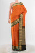 Brick Orange Kanchipuram Silk Saree with Zari Butta on the body and Silk Border.  displayed on a mannequin