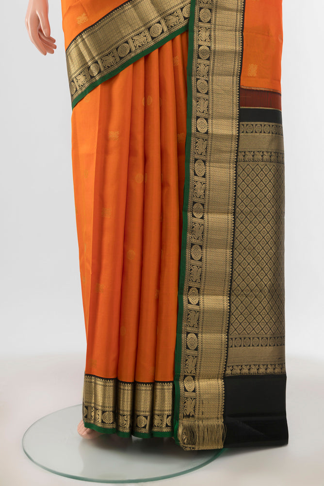 Pleats and pallu of Orange Kanchipuram Silk Saree with Zari Butta on the body and Zari Border. 