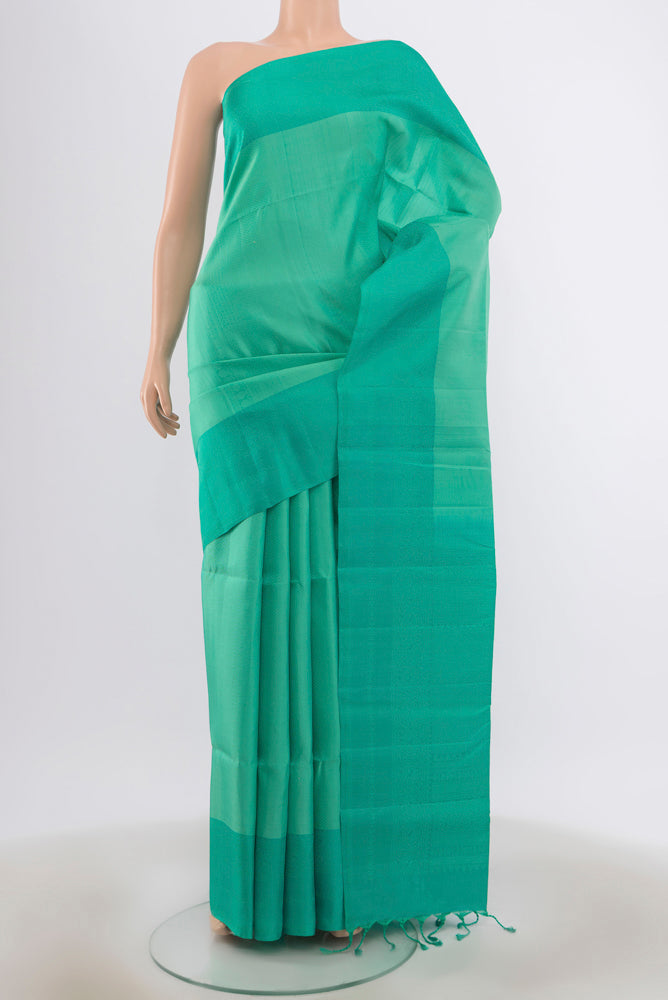 Turquoise Soft Silk Saree with Zari Butta on the body and Plain Border.  displayed on a mannequin