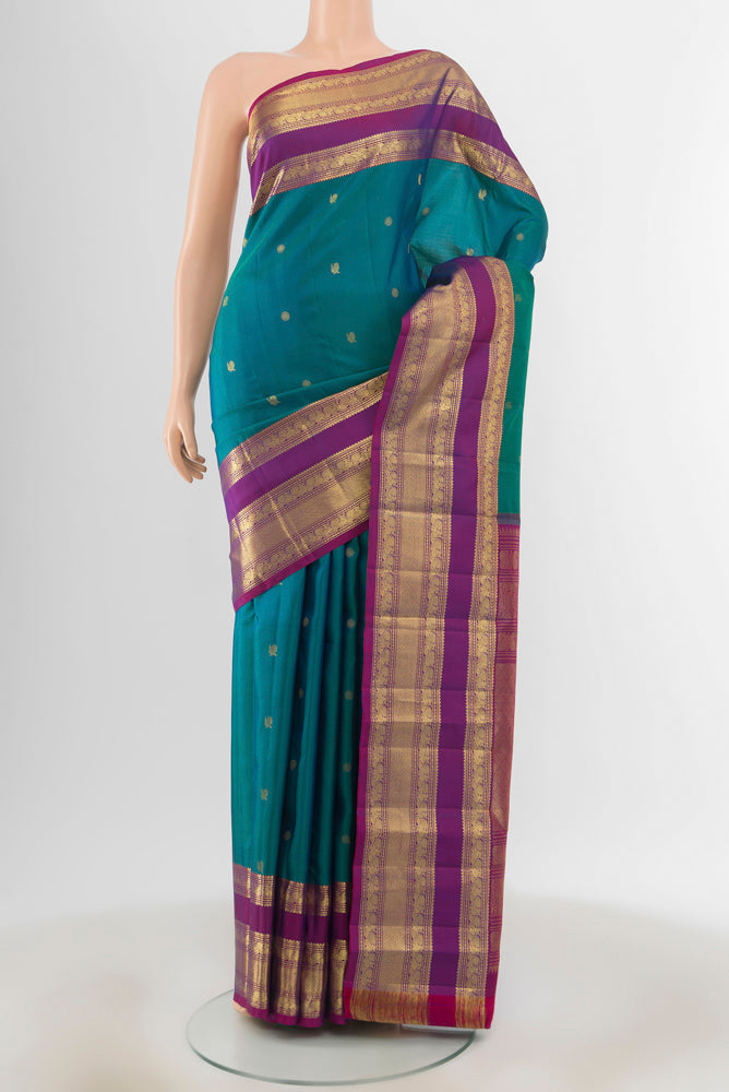 Peacock Blue Kanchipuram Silk Saree with Zari Butta on the body and Zari Border.  displayed on a mannequin